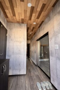 打ちっぱなし風のクロスと木目のクロスがシックでかっこいい(玄関)